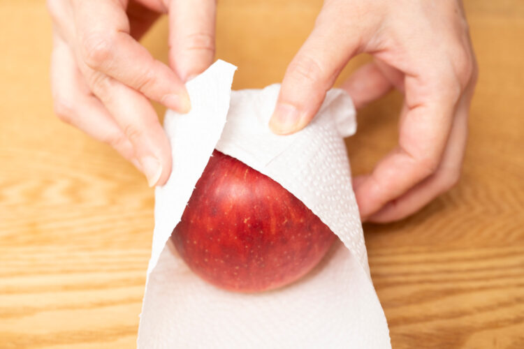 リンゴをキッチンペーパーで包み込む